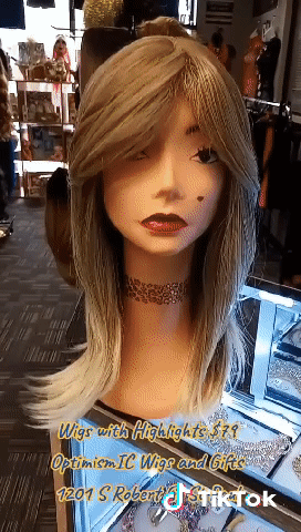 White Mannequin head with a tattooed necklaceon pink store counter modeling Empire Blonde Glueless Synthetic shoulder length Hair Wigs for $79 at Optimismic Wigs and Gifts Shop in St Paul Minnesota. 